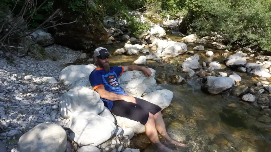 Coach Kelvin dipping his feet in a stream